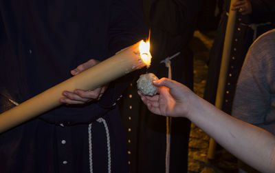 Midsection of woman holding burning candles