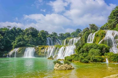 Scenic view of waterfall against sky