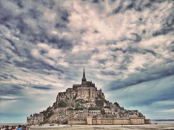 Low angle view of temple building against cloudy sky