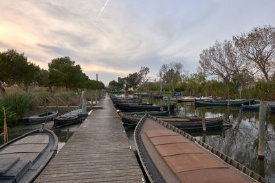 Boats moored in canal against sky