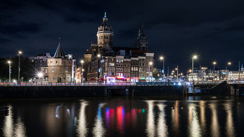 Illuminated basilica of st nicholas by river in city at night