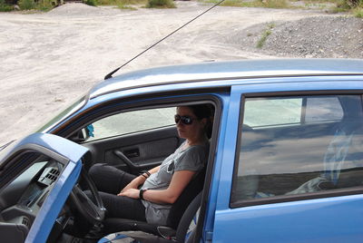 Side view of woman sitting in car