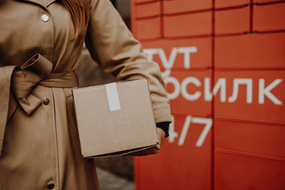 Midsection of woman holding parcel outdoors