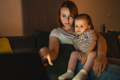 Portrait of boy sitting on sofa at home