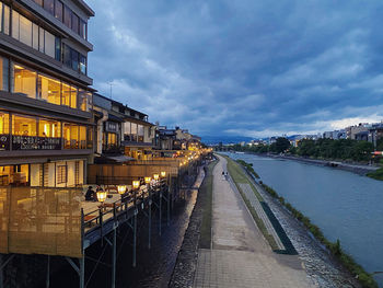 River amidst buildings in city against sky