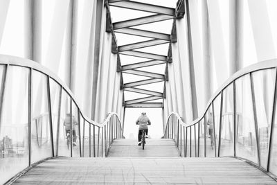 Rear view of woman walking on bridge