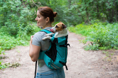 Side view of woman with dog on field