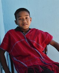 Portrait of boy standing against wall