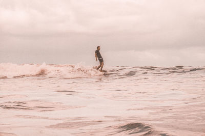 Man surfing in sea against sky