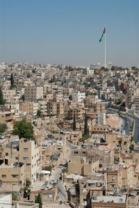 Portrait view of amman city in jordan with buildings and flagpole