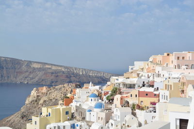 Aerial view of townscape by sea against sky