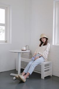 Full length of woman sitting on bench