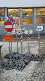 Text on road sign against built structures