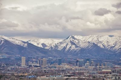 Aerial view of townscape and mountains against sky