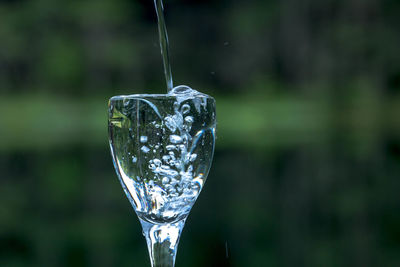 Water pouring in wineglass