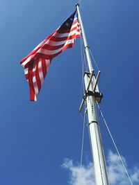 Low angle view of american flag against blue sky