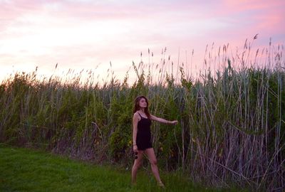 Woman standing on field against sky