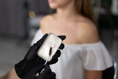 Beautician with brush standing against customer