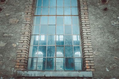 Low angle view of glass window on old building