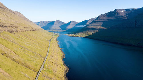 Scenic view of land and mountains against clear blue sky