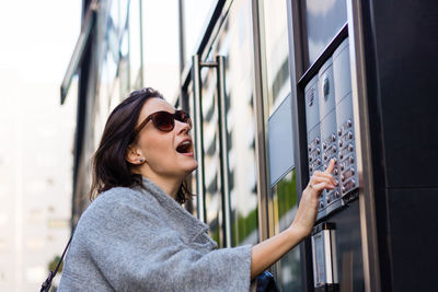 Beautiful woman using intercom