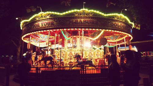 People at amusement park ride at night