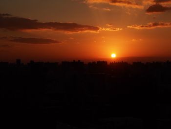 Silhouette cityscape against sky during sunset
