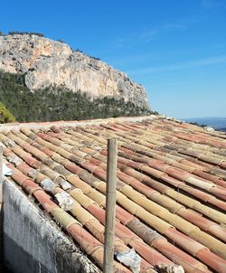 Stack of rocks on roof against clear blue sky