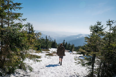 Rear view of man walking on mountain