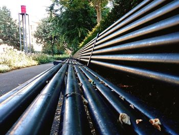 Close-up of metallic pipe against trees