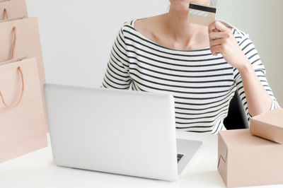 Rear view of woman using mobile phone at home