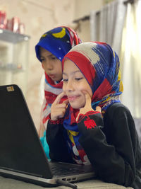 Online learning become a new norm nowadays and a potrait shows two girls are   looking at computer