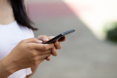 Midsection of woman using mobile phone