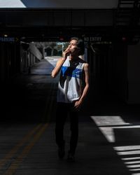 Man smoking cigarette while standing in underground walkway