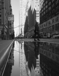 Reflection of woman on city at waterfront