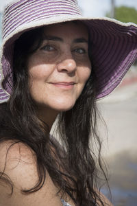 A woman wearing pink hat and looking at the camera. 