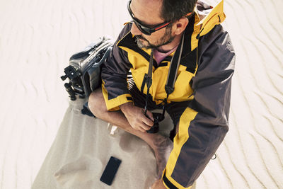 Man camera and mobile phone sitting at desert