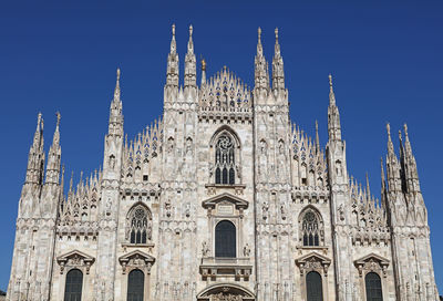 Low angle view of gothic style cathedral against blue sky