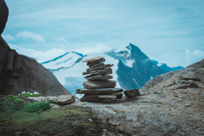 Stack of rocks on mountains against sky