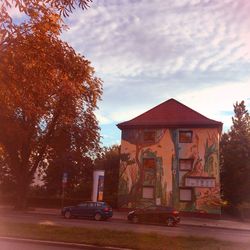 Cars by trees against sky during autumn