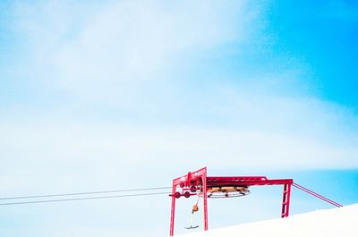 Low angle view of overhead cable car station against sky