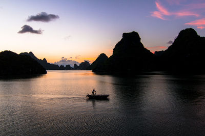 Local fisherman rowing his sampan along the beautiful ha long bay - ha long bay, vietnam