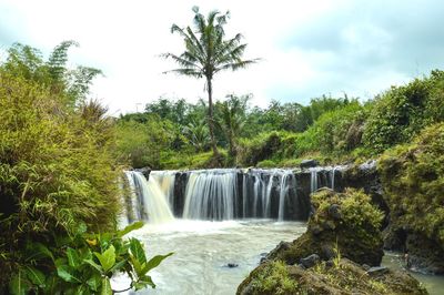 Scenic view of waterfall against sky