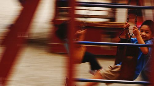 Blurred motion of happy boy enjoying swing