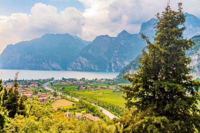 Scenic view of townscape by mountains against sky