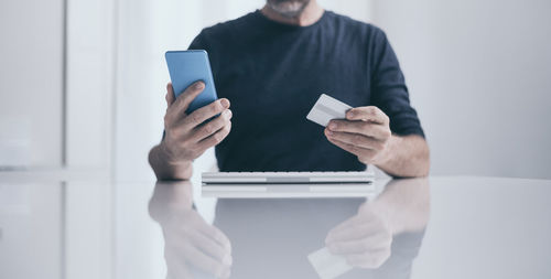 Midsection of woman using mobile phone