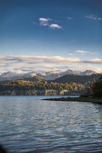 Scenic view of lake by mountain against sky