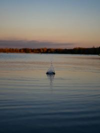 Scenic view of lake against sky at sunset