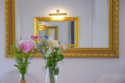 Close-up of illuminated flower vase against wall at home