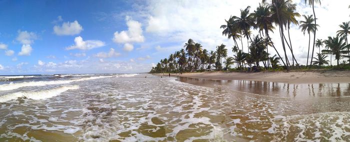 Scenic view of beach against cloudy sky